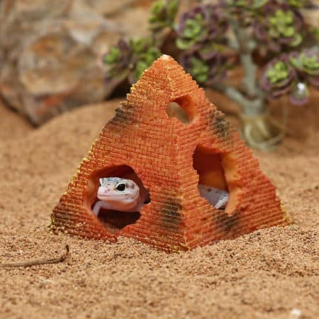 Miniature desert reptile hide with a gecko peeking out from a brick-shaped shelter.
