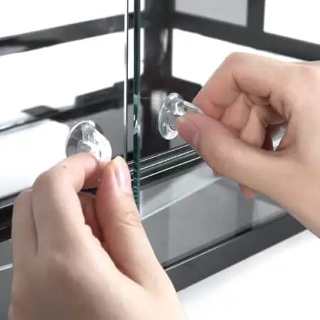 Close-up of hands attaching glass doors to a reptile terrarium.